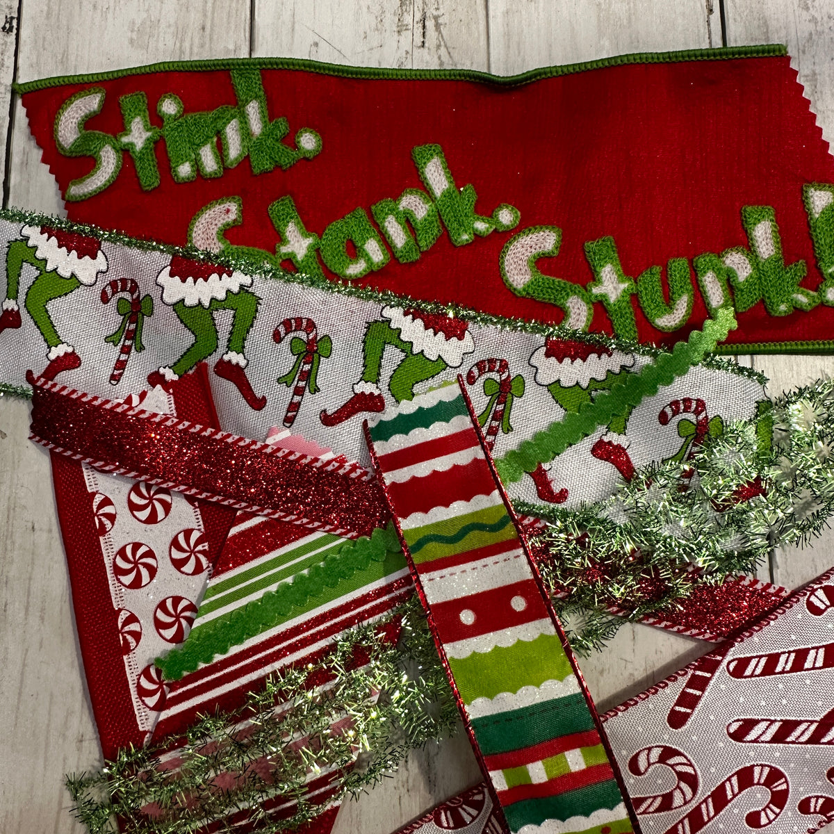 Collection of Christmas-themed decorative items with candy cane patterns on a wooden surface.