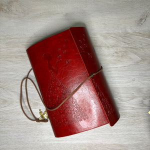 Butterfly embossed woman on red journal with completed pages