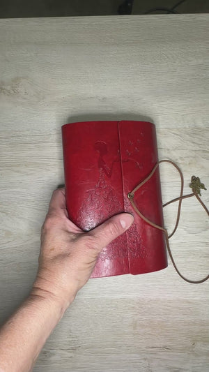Butterfly embossed woman on red journal with completed pages